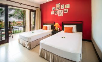 a hotel room with two beds , one on the left and one on the right side of the room at Pandanus Resort