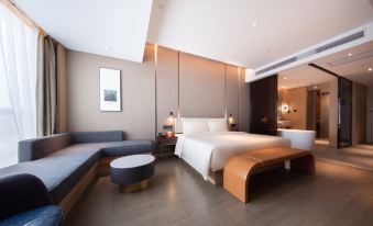 In the modern bedroom, there is a large bed and a bench in the middle, as well as a side table at ATOUR HOTEL,Happy Avenue, Shunde OCT Harbour Branch, Foshan