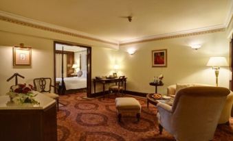 a well - lit living room with various pieces of furniture , including a couch , chairs , and a dining table at Pearl Continental Hotel, Lahore