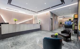 The lobby features a clean and modern design, highlighted by a spacious marble reception desk that creates an inviting atmosphere at Home Inn (Shanghai Pudong Airport)