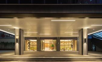 At night, a hotel entrance with large windows and a lit doorway at JI Hotel (Shenzhen Huaqiangbei Huaqiang Road Subway Station)