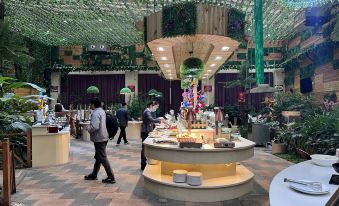 a restaurant with a green ceiling , people standing around , and various food items on display at Gushi Oriental Earl Hotel (Yucheng Avenue Genqin Culture Park)