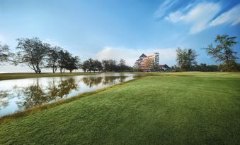 a large body of water , possibly a lake or a pond , surrounded by a grassy field at Resorts World Kijal