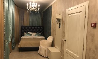 a luxurious bedroom with a large bed , a chair , and a chandelier hanging from the ceiling at Vernisage