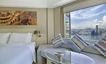 A bedroom with large windows and a balcony that overlooks the city, equipped with an additional bed at Hotel Alexandra