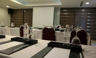 a conference room set up for a meeting , with chairs arranged in rows and a table in the center at Hotel Sfera