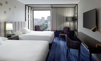 a hotel room with two beds , one on the left and one on the right side of the room at DoubleTree by Hilton Montreal