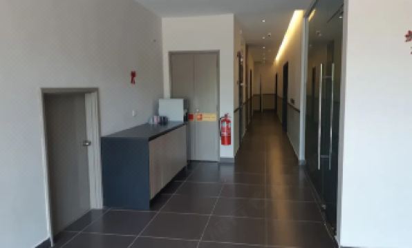 a long , empty hallway with a counter and fire extinguisher on the right side at Monaco Hotel