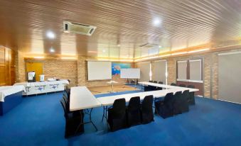 a large room with a long table and chairs , a projector screen , and air conditioning units at Carnarvon Motel