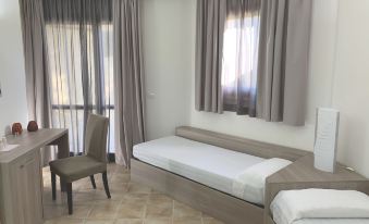 a hotel room with two beds , one on the left side of the room and the other on the right side at VOI Arenella Resort