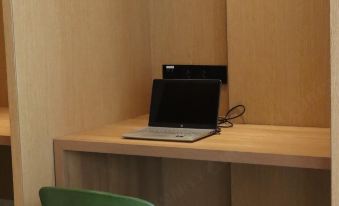 In the middle room, there is a small desk with a chair and a computer, as well as a wooden table at Holiday Inn Express Xiamen Tongan