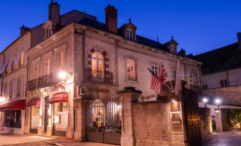 a large building with a flag and an american flag on the front of the building at L'Hotel de Beaune