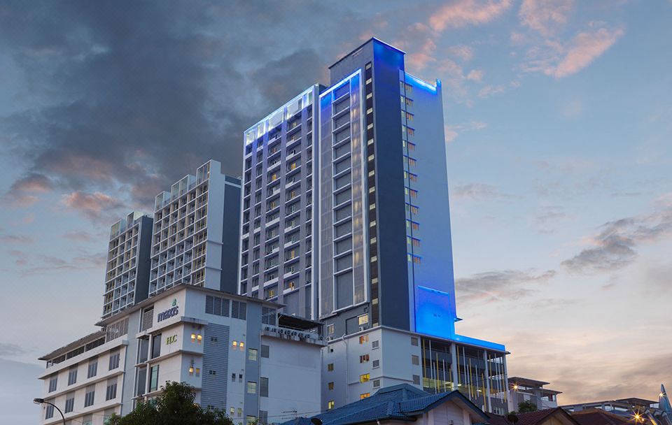 a tall building with blue lights on it is surrounded by other buildings in the city at Best Western I-City Shah Alam