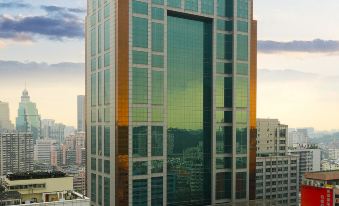 A ground-level view of an office building and surrounding skyscrapers at Asia International Hotel