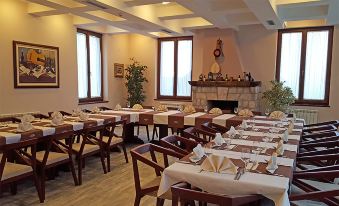 a large dining room with multiple tables and chairs arranged for a group of people to enjoy a meal together at Hotel Monte Rosa