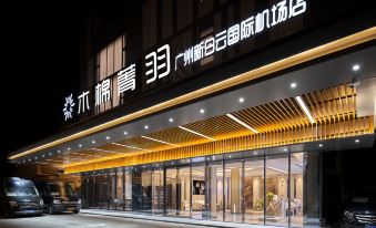 The hotel entrance is illuminated at night with a welcoming sign above it at Mumian Hotel (Guangzhou Baiyun International Airport)