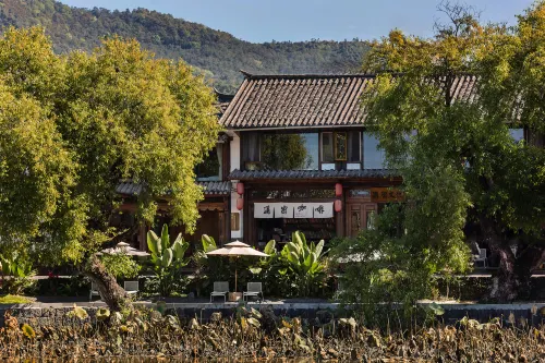 The translation would be: Pumi Hepanshan She Inn (Tengchong Heshun Branch) - ที่มีบาร์