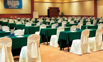 a conference room with rows of tables and chairs , each table has a green tablecloth at Resorts World Langkawi