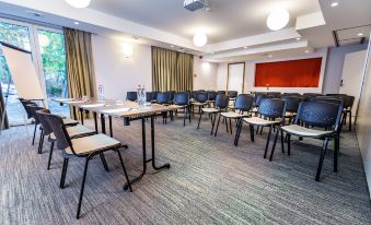 a conference room set up for a meeting , with tables and chairs arranged in a semicircle at Utopia Hotel - Art & Nature Hotel