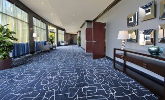 a modern hotel lobby with blue and white carpet , multiple couches , chairs , and a large window at Holiday Inn Hammond