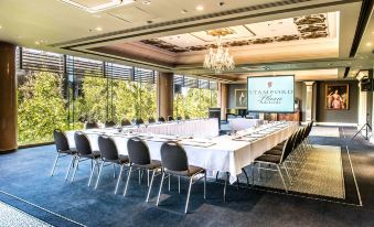 a conference room with a large table , chairs , and a screen displaying the stanford data center logo at Stamford Plaza Adelaide