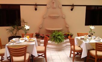 a dining room with a table set for breakfast and a fountain in the background at Hotel San Francisco