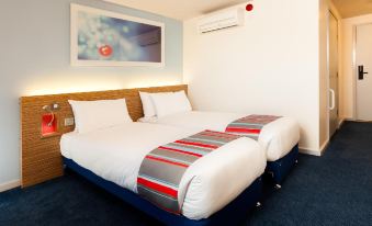 a hotel room with two beds , one on the left and one on the right side of the room at Travelodge Hull South Cave