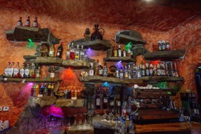 a well - stocked bar with various bottles and wine glasses , creating an inviting atmosphere for patrons at Troll