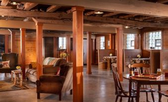 a spacious living room with wooden columns , a couch , and dining tables in the background at Justin Trails Resort