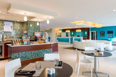 a dining area with a table and chairs , as well as a kitchen in the background at Wyndham Reef Resort Grand Cayman