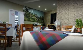 a dining room with a table covered in a colorful checkered tablecloth , surrounded by chairs at The Esquire