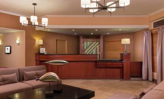 a hotel lobby with a reception desk , a couch , and several chairs arranged around it at DoubleTree by Hilton Portland - Tigard