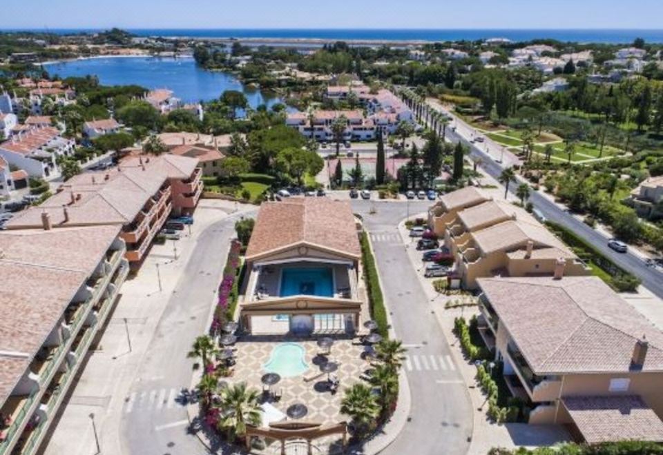 a bird 's eye view of a residential area with houses , a pool , and a water body at Lakeside Country Club - Apartamentos Turísticos