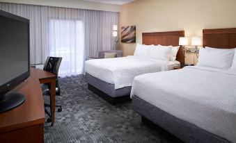 a hotel room with two beds , one on the left and one on the right side of the room at Courtyard Detroit Dearborn