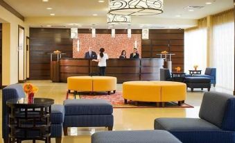 a hotel lobby with a reception desk , couches , chairs , and a chandelier hanging from the ceiling at Marriott Saddle Brook