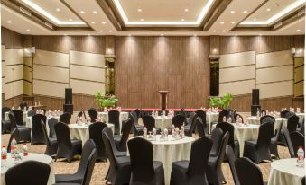 a large banquet hall with round tables and chairs set up for a formal event at Hotel Horison Gkb Gresik