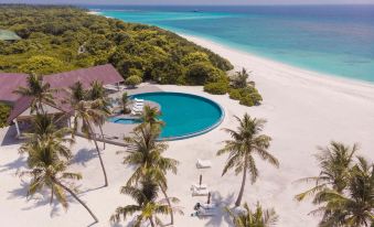 a luxurious resort with a large pool surrounded by palm trees and a sandy beach at Hondaafushi Island Resort