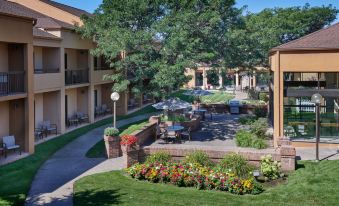 a courtyard surrounded by buildings , with tables and chairs set up for outdoor dining or socializing at Courtyard Detroit Dearborn