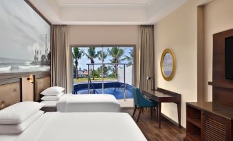 a hotel room with two beds , a desk , and a window overlooking a pool area at Sheraton Kosgoda Turtle Beach Resort