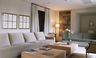 a spacious living room with a large couch , a coffee table , and several chairs arranged around it at Parador de La Granja