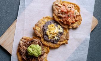 a close - up view of a plate filled with three different types of food , including tacos and guacamole at Selina Jaco