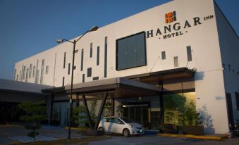 "a white building with a car parked in front of it and the word "" hangar hotel "" displayed above it" at Hangar Inn Guadalajara Aeropuerto