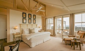 a spacious bedroom with a large bed , white linens , and a view of the ocean at Rosewood Cape Kidnappers