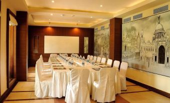 a large conference room with a long table covered in white tablecloths and chairs arranged around it at Country Roads