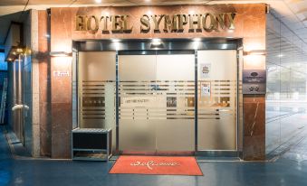 "the entrance of a hotel named "" hotel symphony "" with its glass doors and a red carpet" at Symphony Hotel