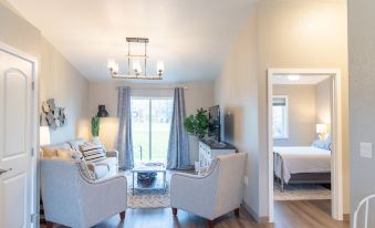 a living room with two couches , a coffee table , and a television mounted on the wall at Colony Suites