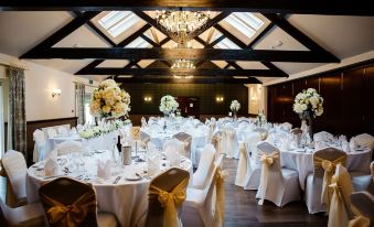 a large banquet hall with tables covered in white tablecloths and chairs arranged for a formal event at Irton Hall