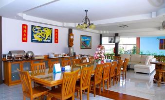 a well - decorated dining room with a long table and chairs , along with artwork on the walls at Hugpua Hotel