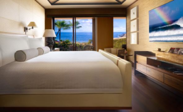 a spacious bedroom with a king - sized bed , hardwood floors , and a view of the ocean at Four Seasons Resort Lana'i
