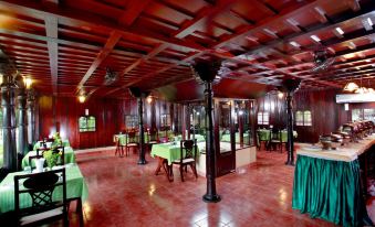 a large dining room with wooden tables and chairs arranged for a group of people to enjoy a meal at Paradise Resorts